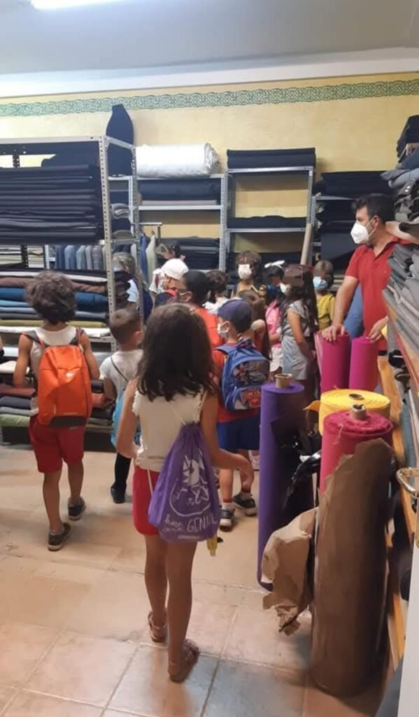 Niños visitando almacén textil